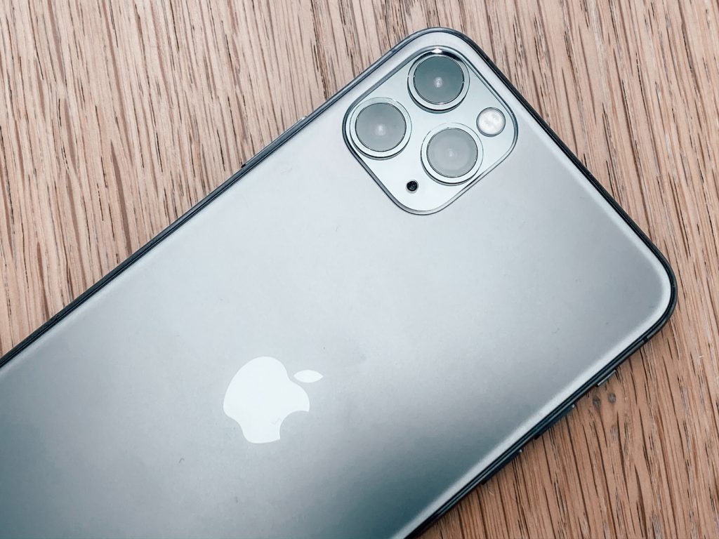 An iPhone 11 pro face down on a wooden table top