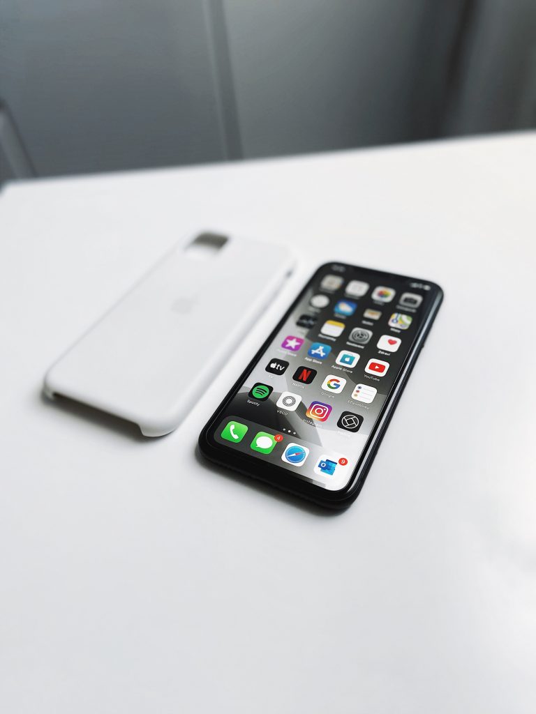 An iPhone placed on a white desk