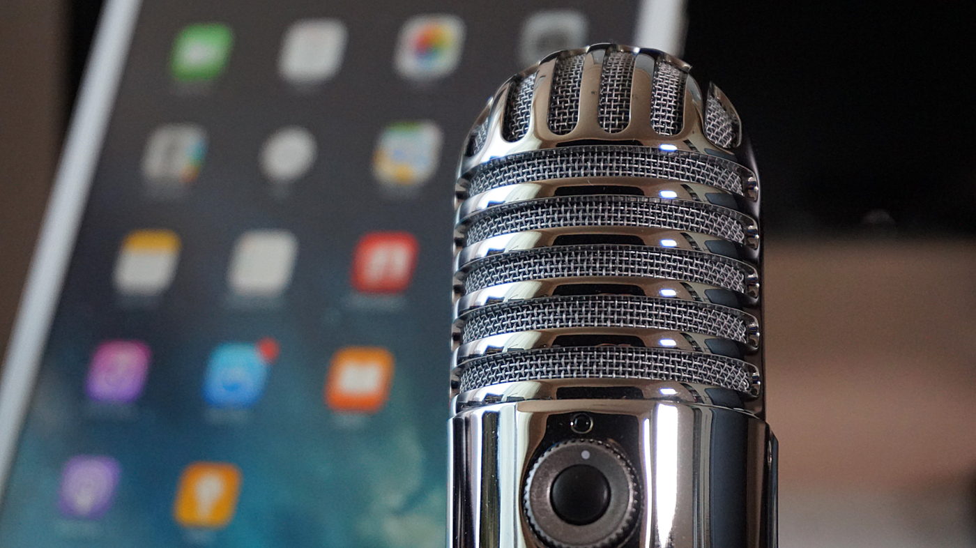 A microphone set up in-front of a tablet for a podcast