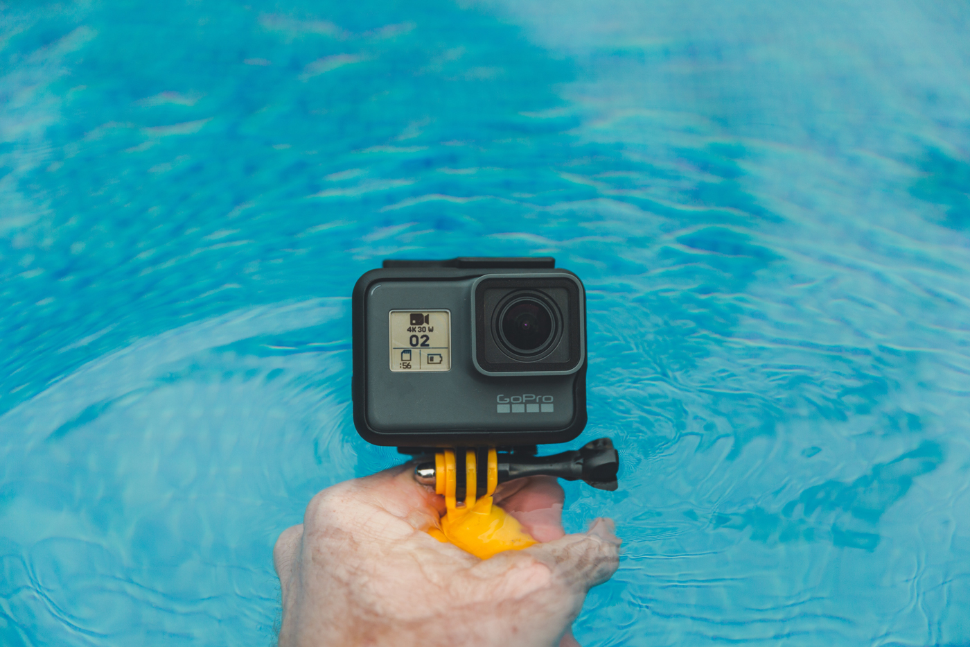 A GoPro on a stand about to be submerged in water