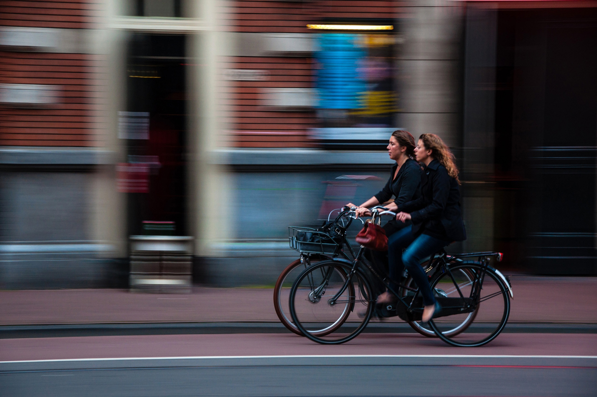 Two cyclists commuting through a city street