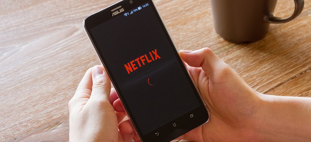A person loading the Netflix app on their mobile phone