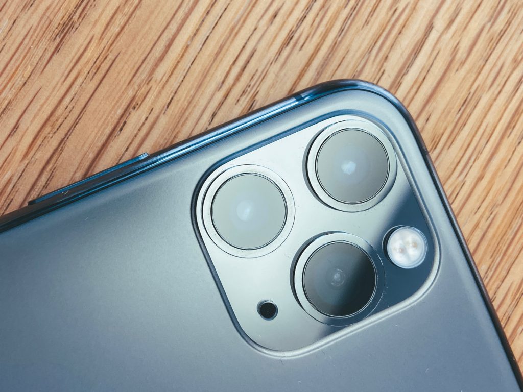 A triple lens camera on the back of an iPhone 11 pro
