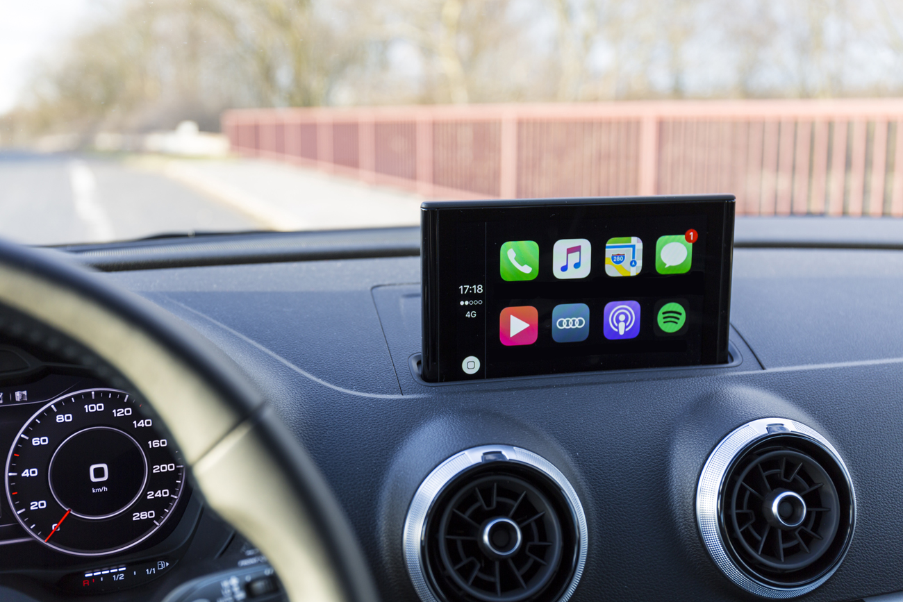 Apple CarPlay loaded on the screen on the dashboard of a car driving along a motorway