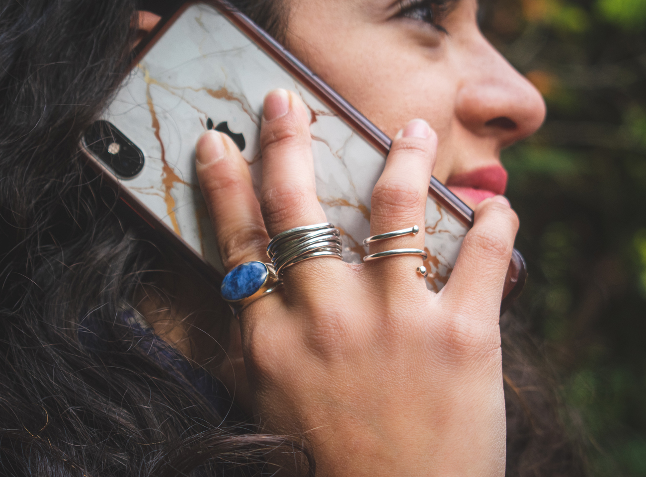 A woman holding an iPhone up to her ear to talk to someone