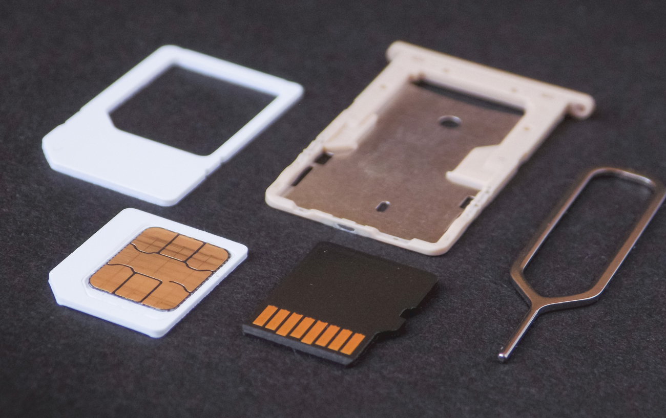 A sim card with a tray and a tool next to it